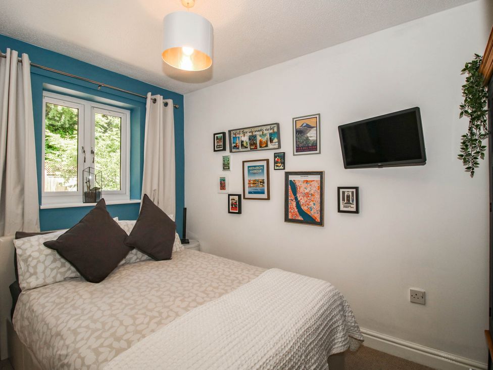 A bedroom with a bed and wall art at Lilac Cottage in Ironbridge