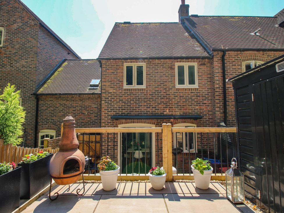 A garden with a chiminea and flower pots at Lilac Cottage in Ironbridge
