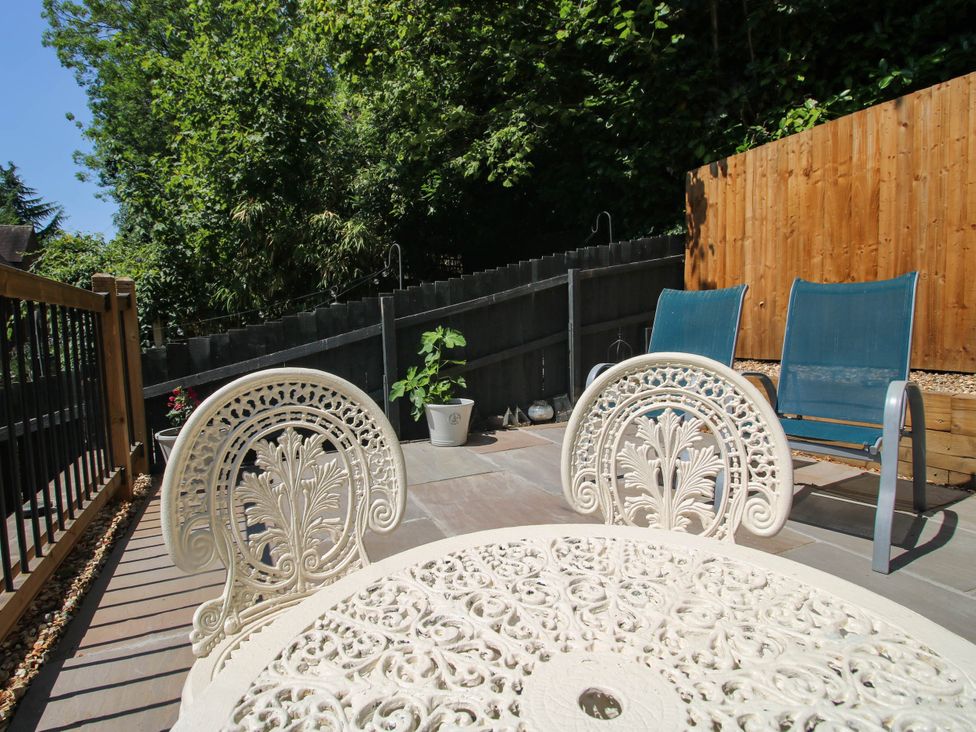 A garden with a table, chairs, and plants at Lilac Cottage in Ironbridge