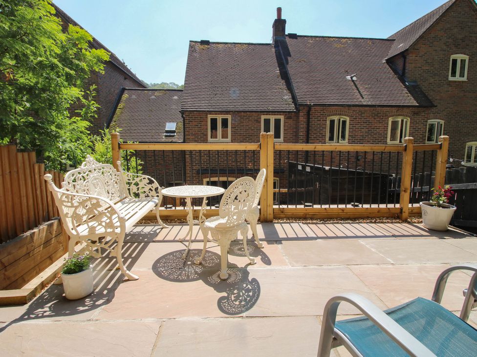 An outdoor patio with a bench and table at Lilac Cottage in Ironbridge