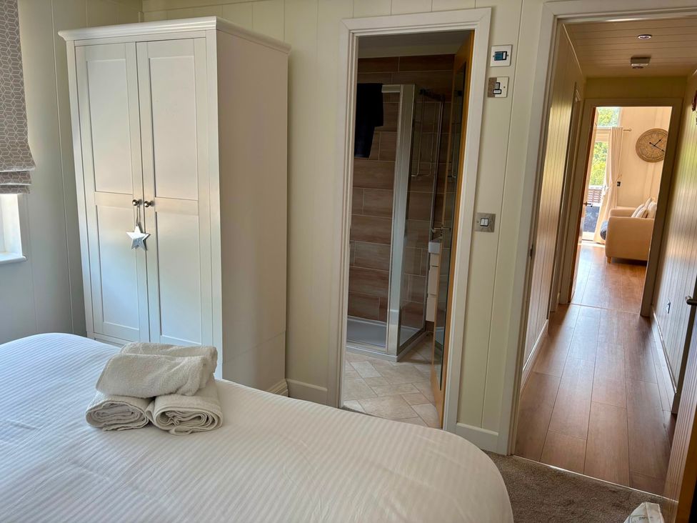 A bedroom with a bed and wardrobe at Lakeside Retreat in Newton Abbot