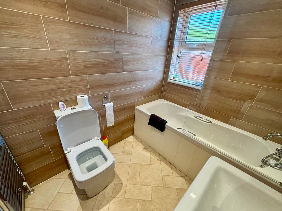 A bathroom with a toilet and bath tub at Lakeside Retreat in Newton Abbot