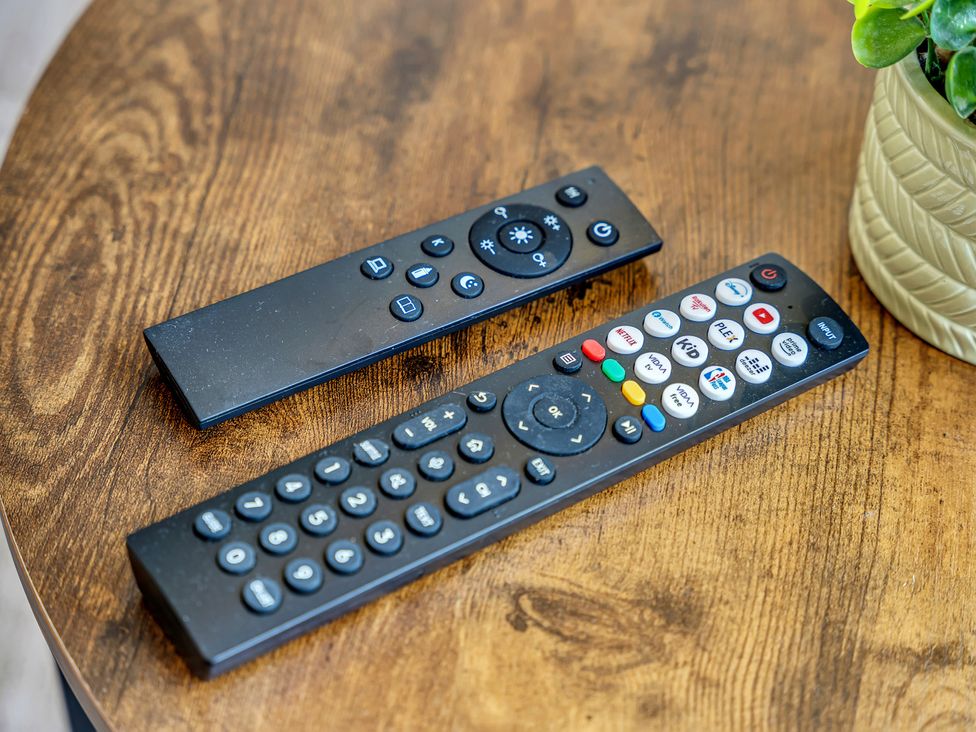 Two remote controls on a wooden table at Peak View Terrace