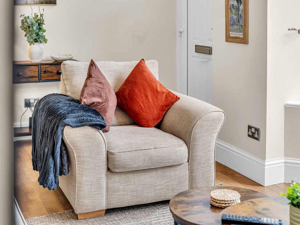 An armchair with cushions and a blanket in a living room at Peak View Terrace