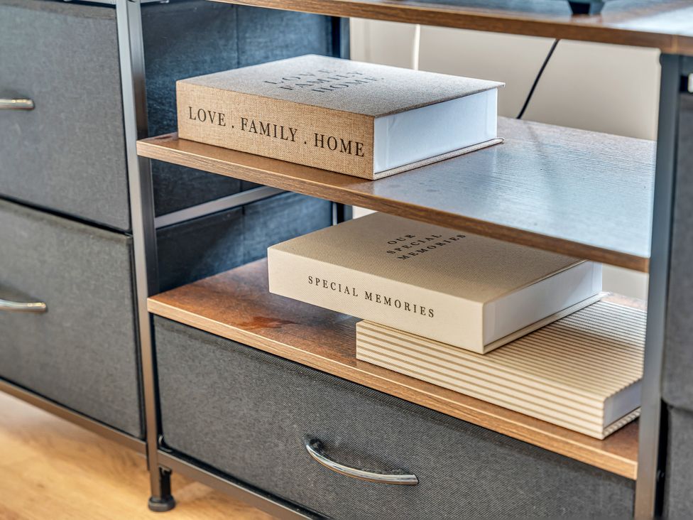 A bookshelf with storage drawers and photo albums at Peak View Terrace