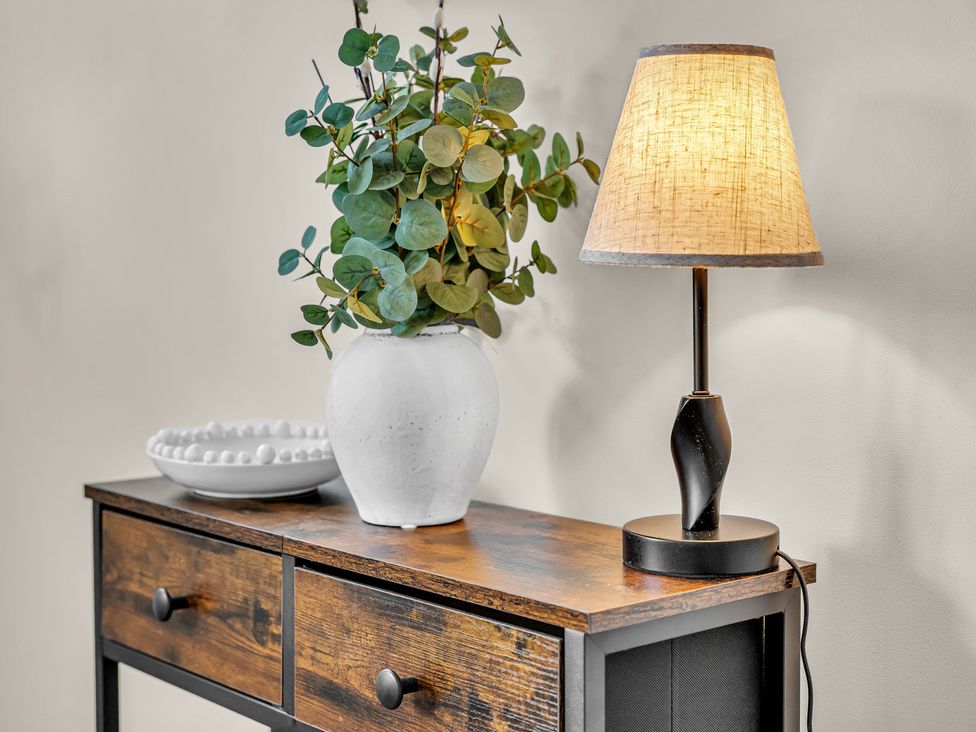 A console table with a lamp, vase of eucalyptus, and bowl at Peak View Terrace