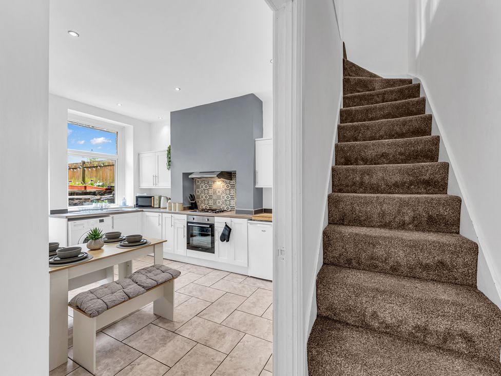 A kitchen with a stove and a staircase at Peak View Terrace