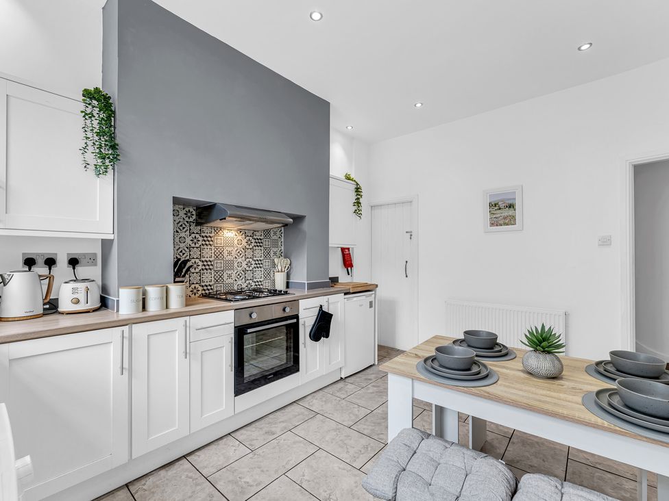 A kitchen with appliances and dining table at Peak View Terrace