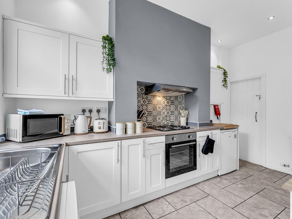 A kitchen with cabinets, microwave, kettle, and stove at Peak View Terrace