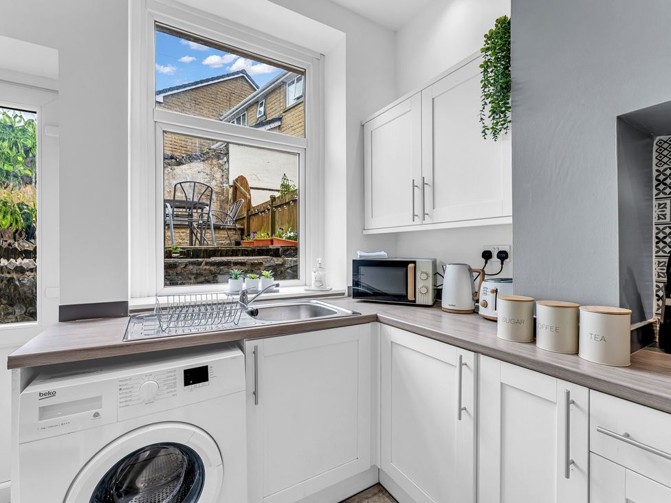 A kitchen with a washing machine and window view at Peak View Terrace