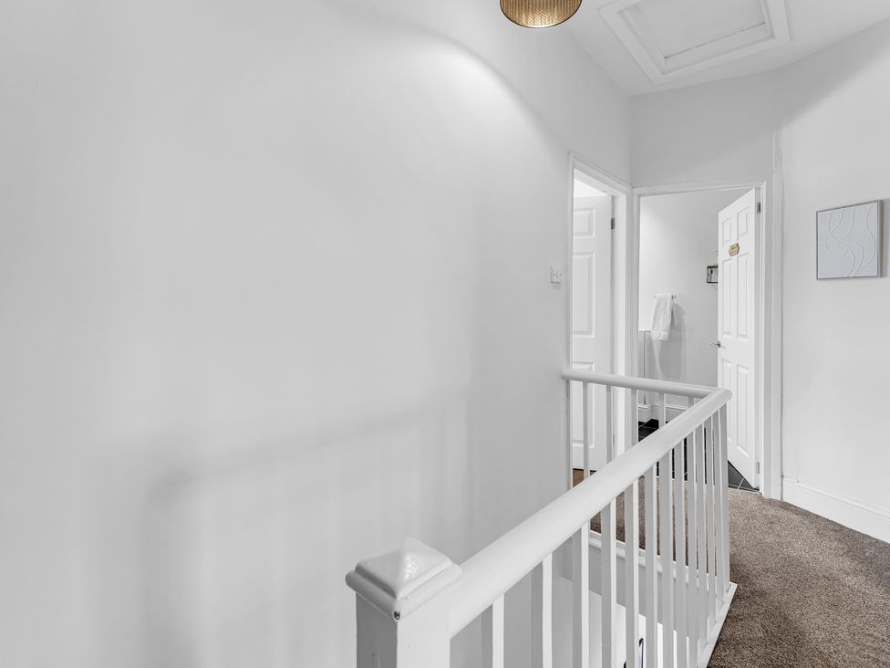 A hallway with doors and a stair railing at Peak View Terrace