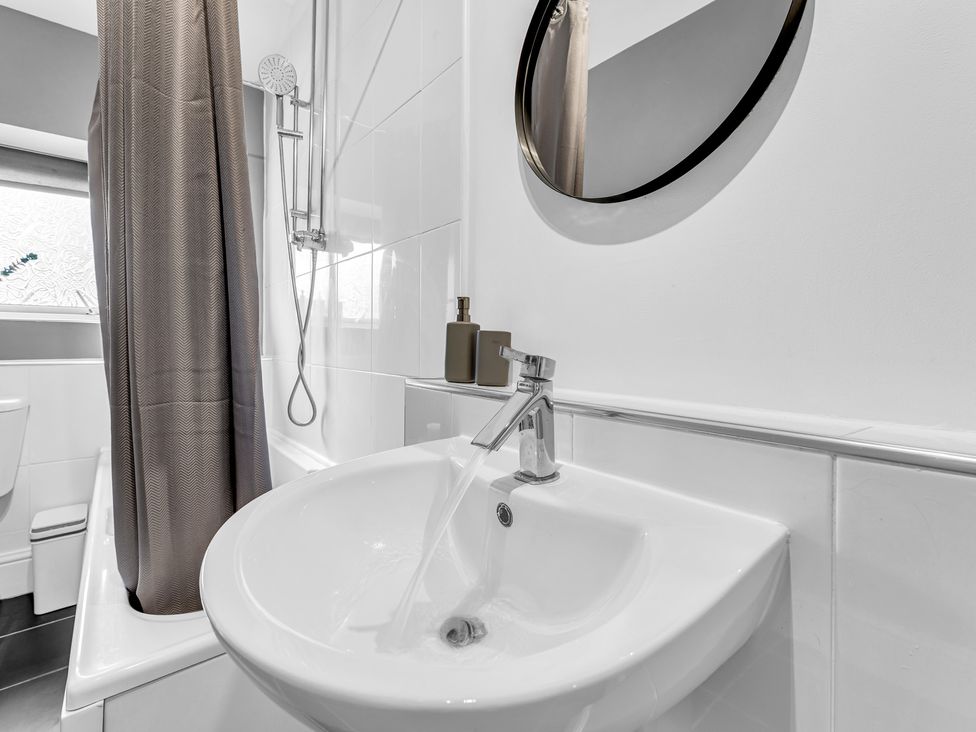 A wash basin with a faucet and mirror in a bathroom at Peak View Terrace 