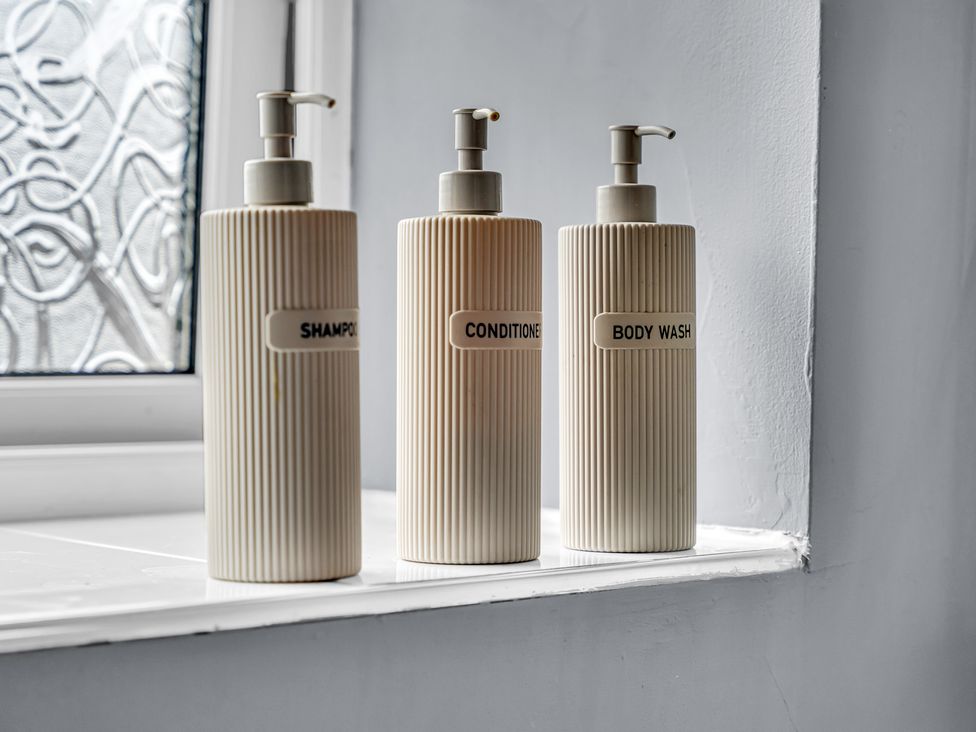 A display of shampoo, conditioner, and body wash bottles in a bathroom at Peak View Terrace