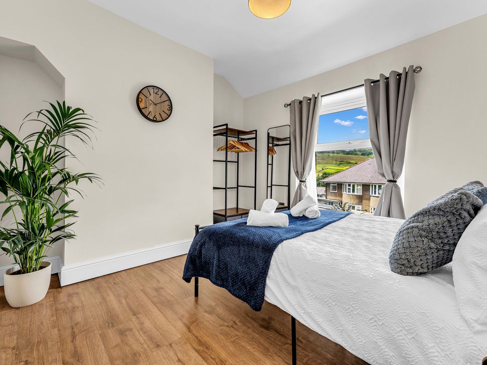 A bedroom with a bed and clock at Peak View Terrace