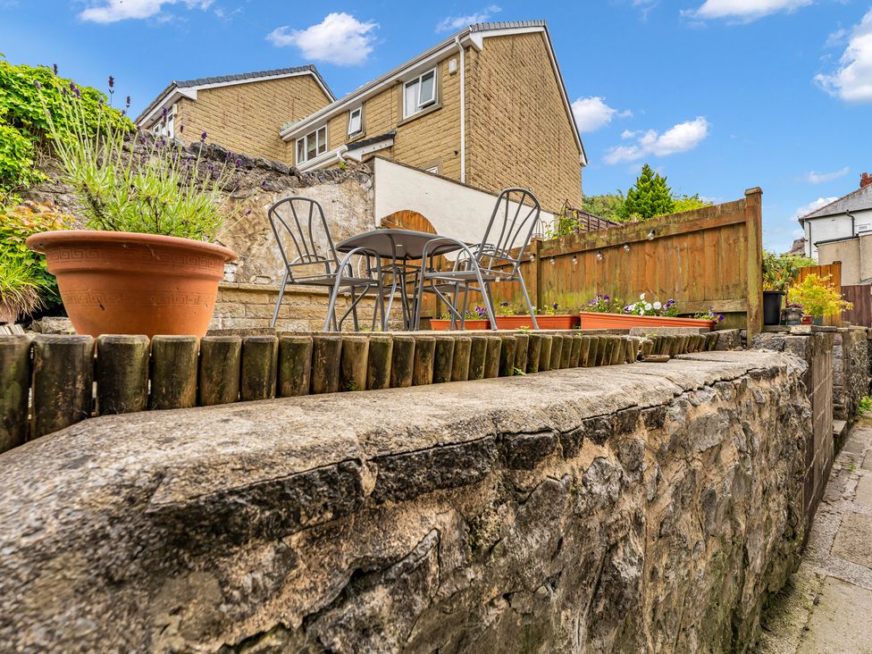 A garden with stone wall and seating area at Peak View Terrace