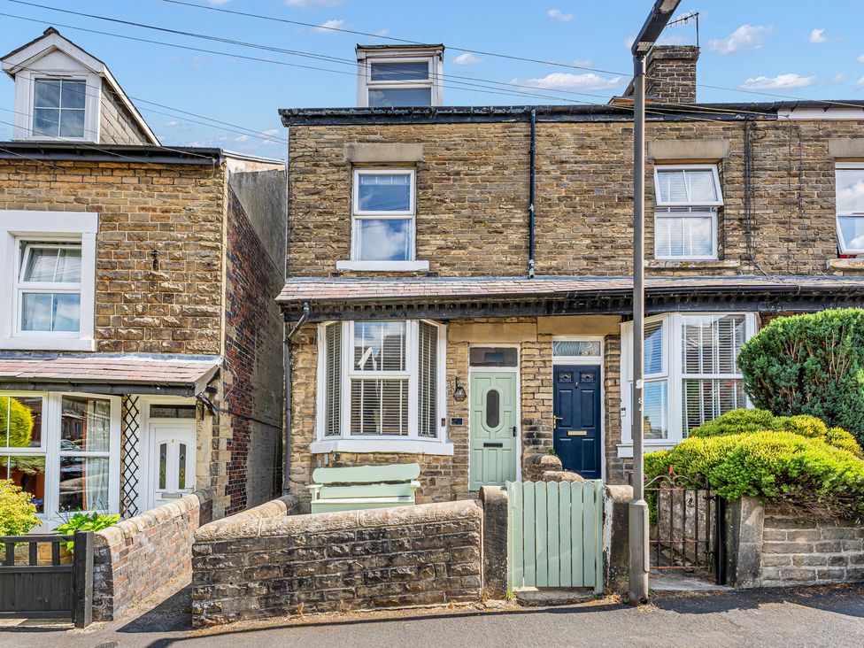 A brick house with two front doors and a garden at Peak Side Terrace in Buxton