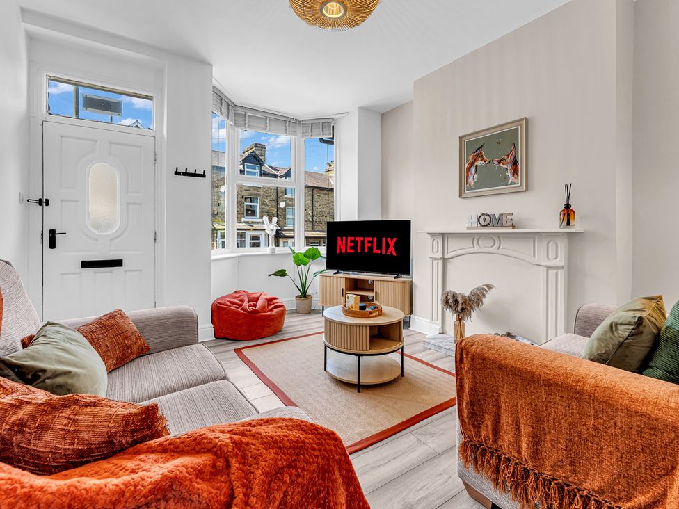 A living room with a television and sofa at Peak Side Terrace in Buxton