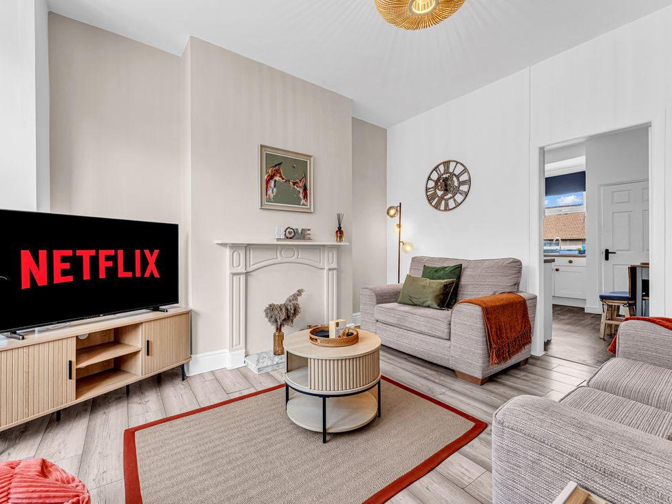 A living room with a television and sofa at Peak Side Terrace in Buxton
