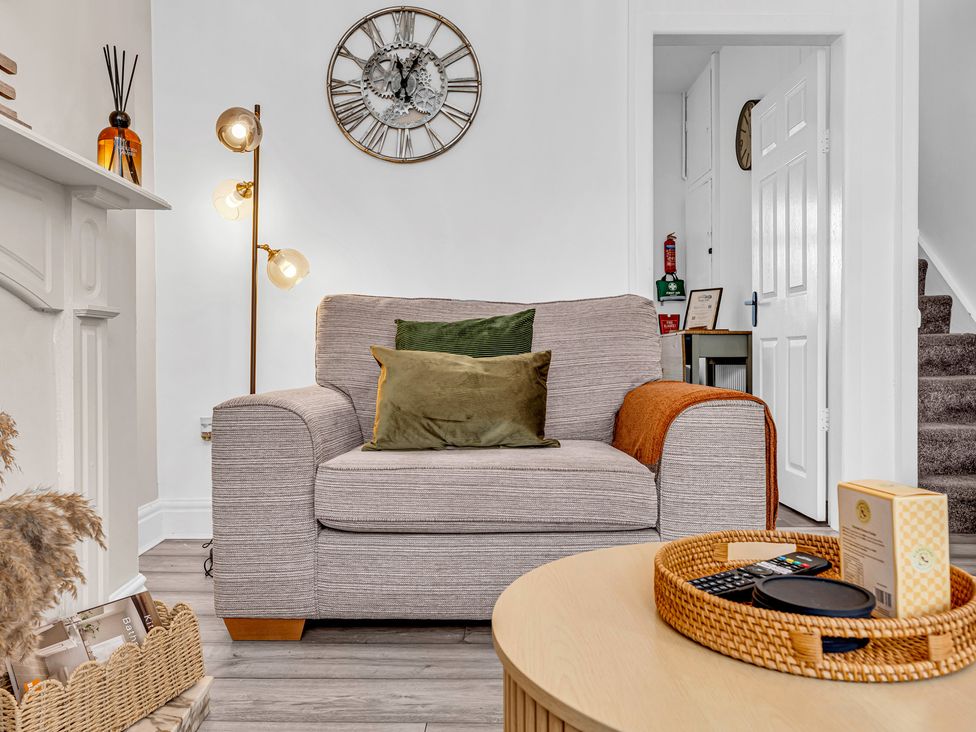 A living room with an armchair and coffee table at Peak Side Terrace in Buxton