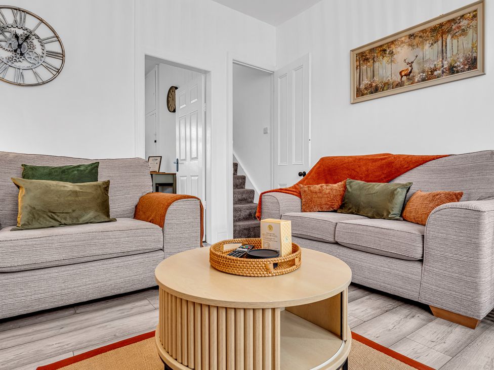 A living room with sofas and a table at Peak Side Terrace in Buxton