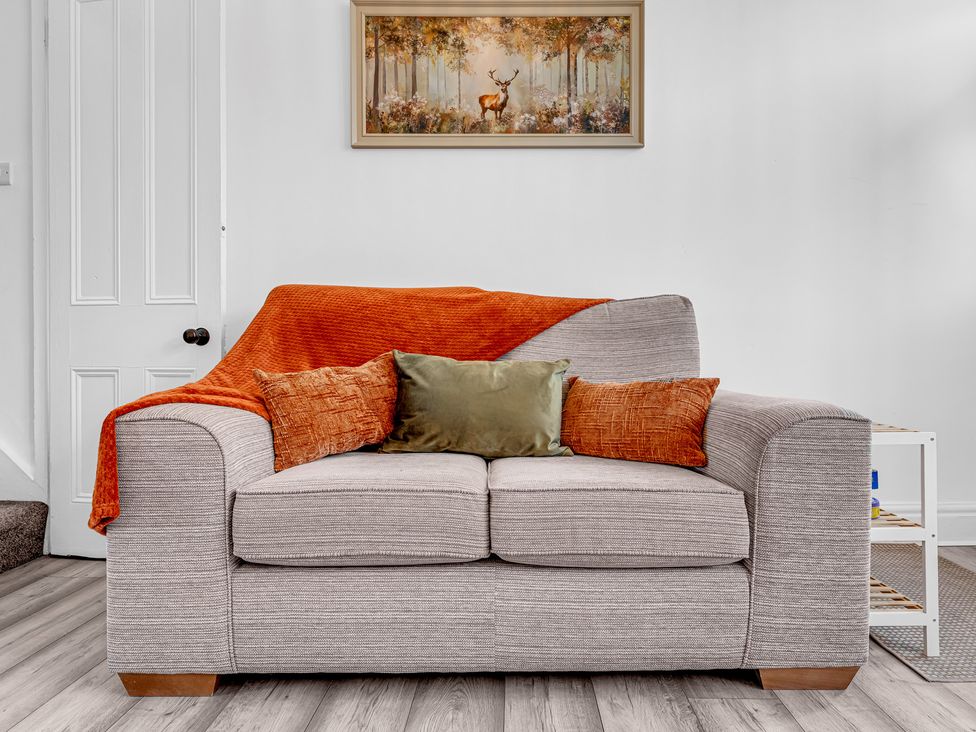 A sofa with cushions and a picture on the wall at Peak Side Terrace in Buxton