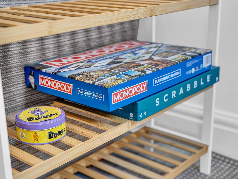 A shelf with board games including Monopoly and Scrabble at Peak Side Terrace Buxton