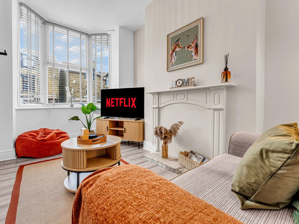A living room with a television and coffee table at Peak Side Terrace in Buxton