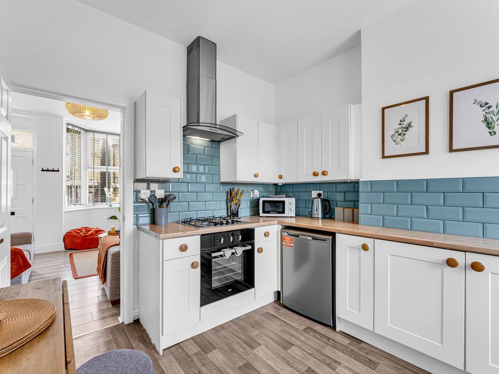 A kitchen with cabinets and appliances at Peak Side Terrace in Buxton