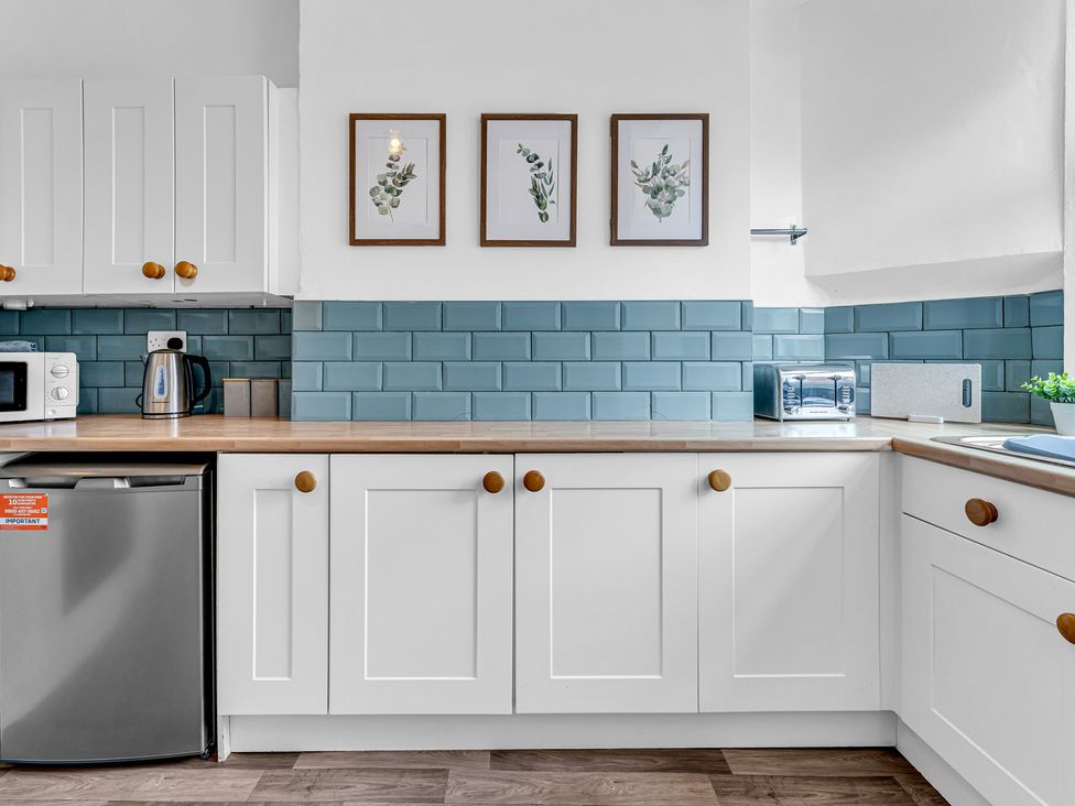A kitchen with appliances and framed plants at Peak Side Terrace in Buxton