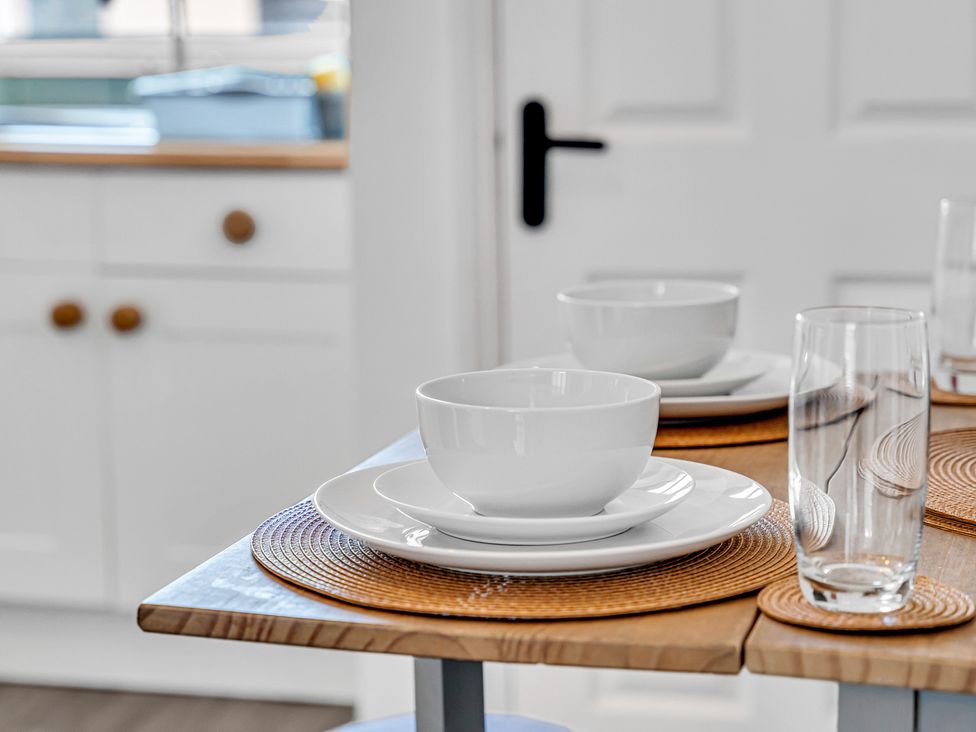 A dining table set with dishes and glassware at Peak Side Terrace in Buxton