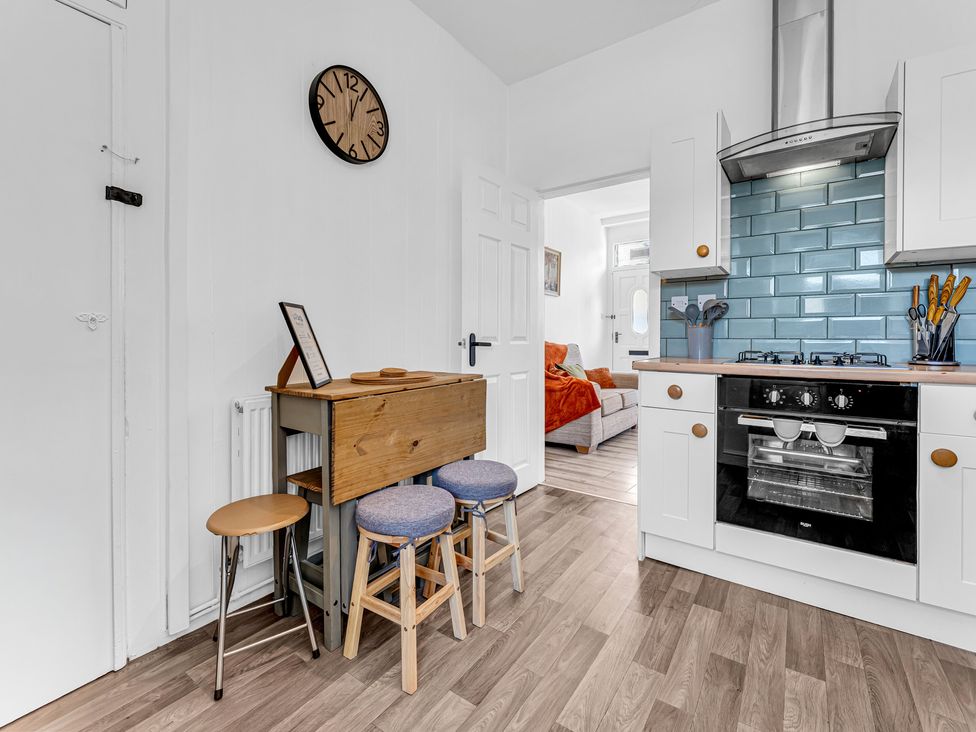 A kitchen with a wooden table and bar stools at Peak Side Terrace in Buxton
