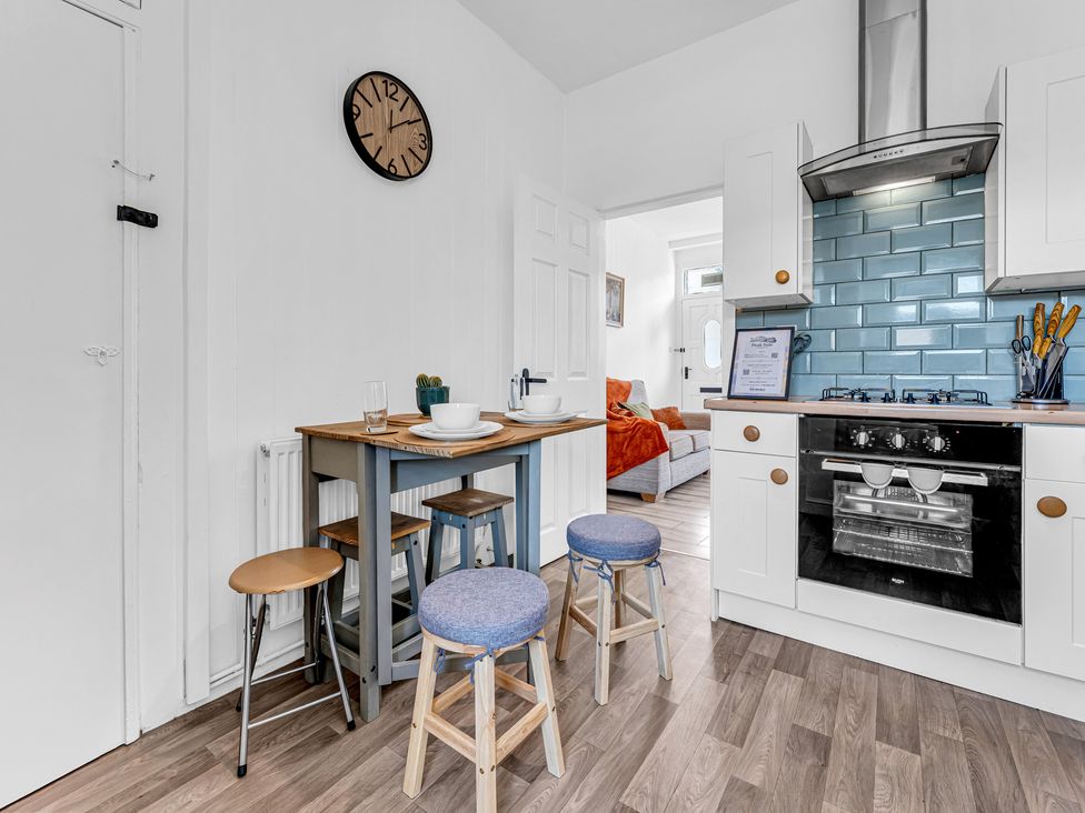 A kitchen with a table and stools at Peak Side Terrace in Buxton