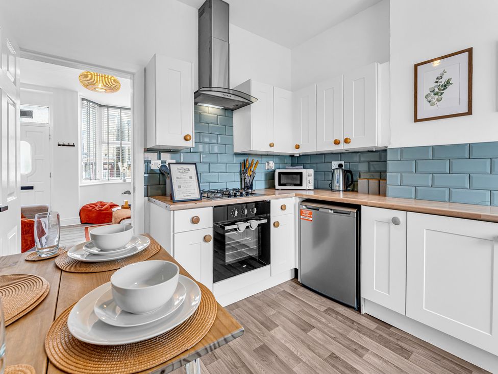 A kitchen with cabinets and appliances at Peak Side Terrace in Buxton