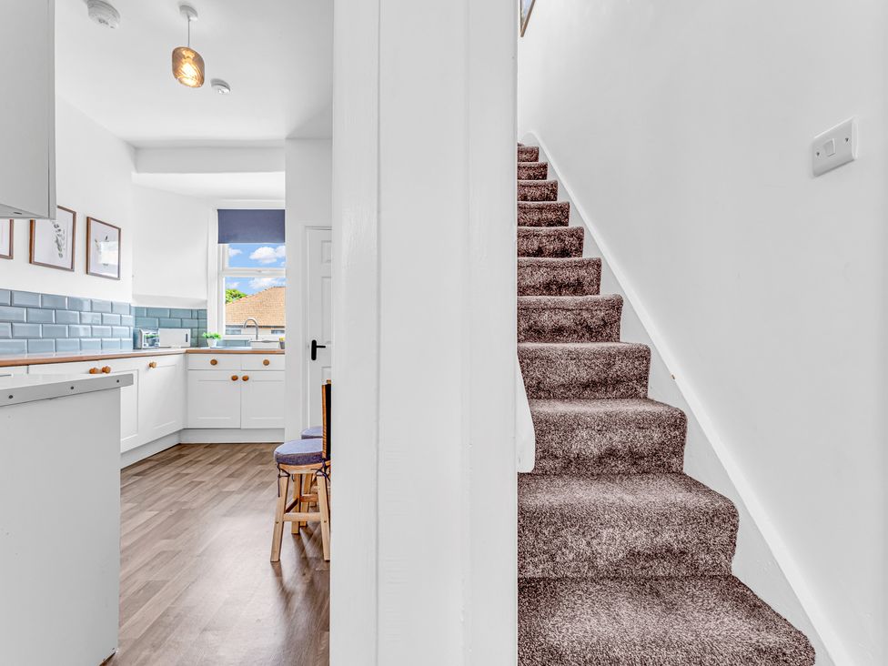 A kitchen with a staircase leading up at Peak Side Terrace Buxton