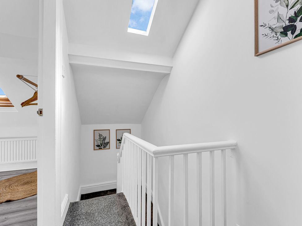 A staircase with skylight and pictures at Peak Side Terrace in Buxton