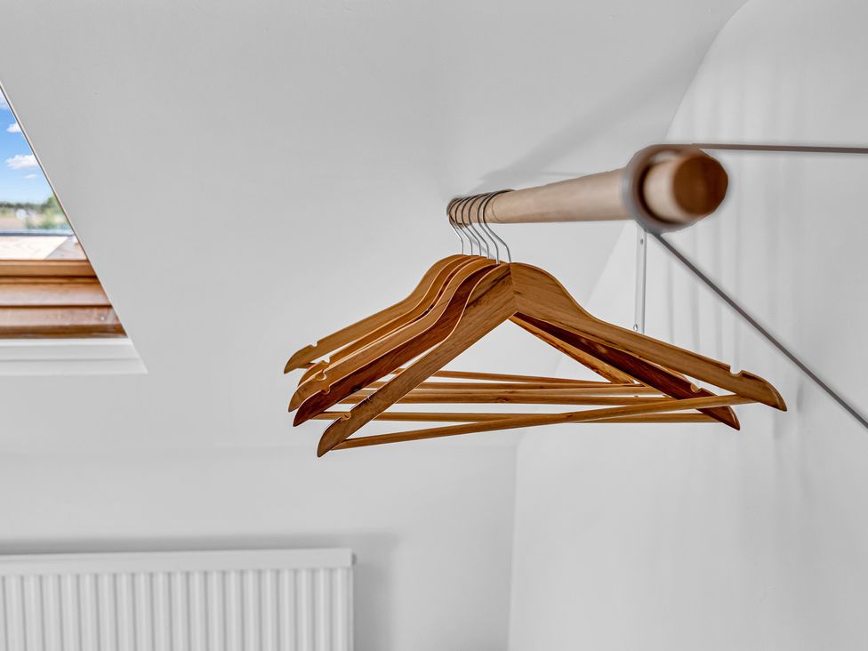 A set of wooden hangers with a window in the background at Peak Side Terrace in Buxton