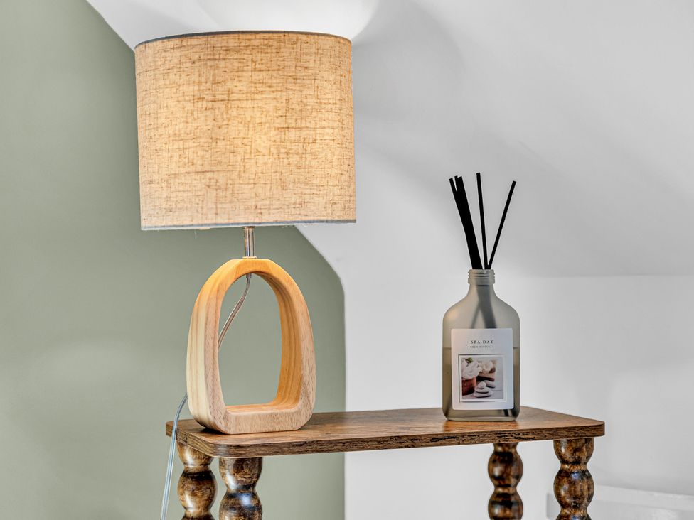 A lamp and decorative bottle on a table at Peak Side Terrace in Buxton