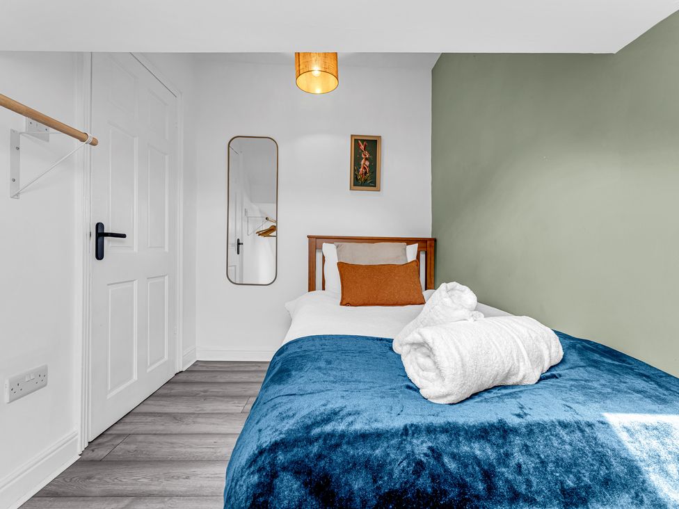 A bedroom with a bed and mirror at Peak Side Terrace in Buxton
