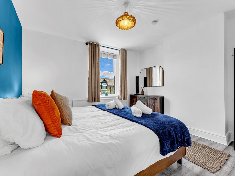 A bedroom with a bed and mirror at Peak Side Terrace Buxton