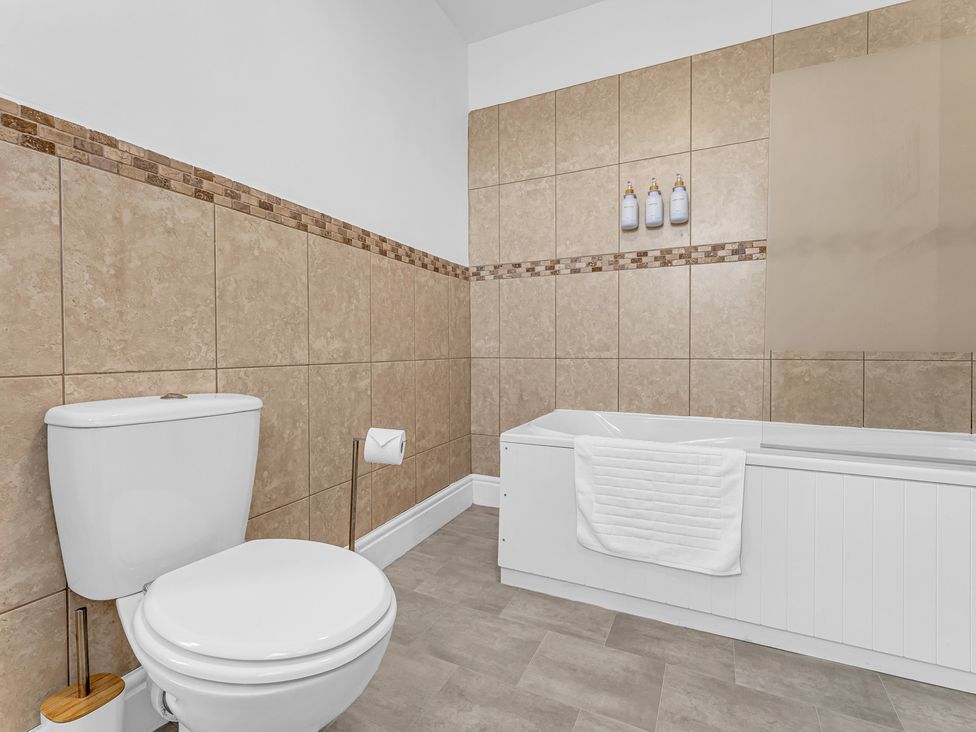 A bathroom with a toilet and bathtub at Peak Side Terrace in Buxton