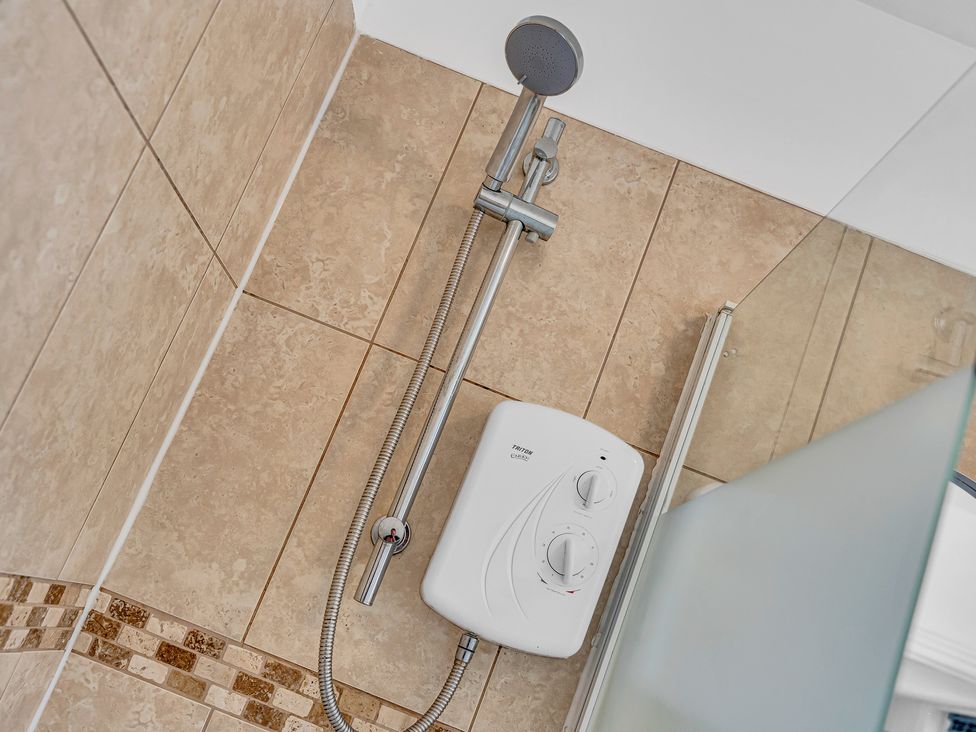 A shower with wall tiles and control unit at Peak Side Terrace Buxton