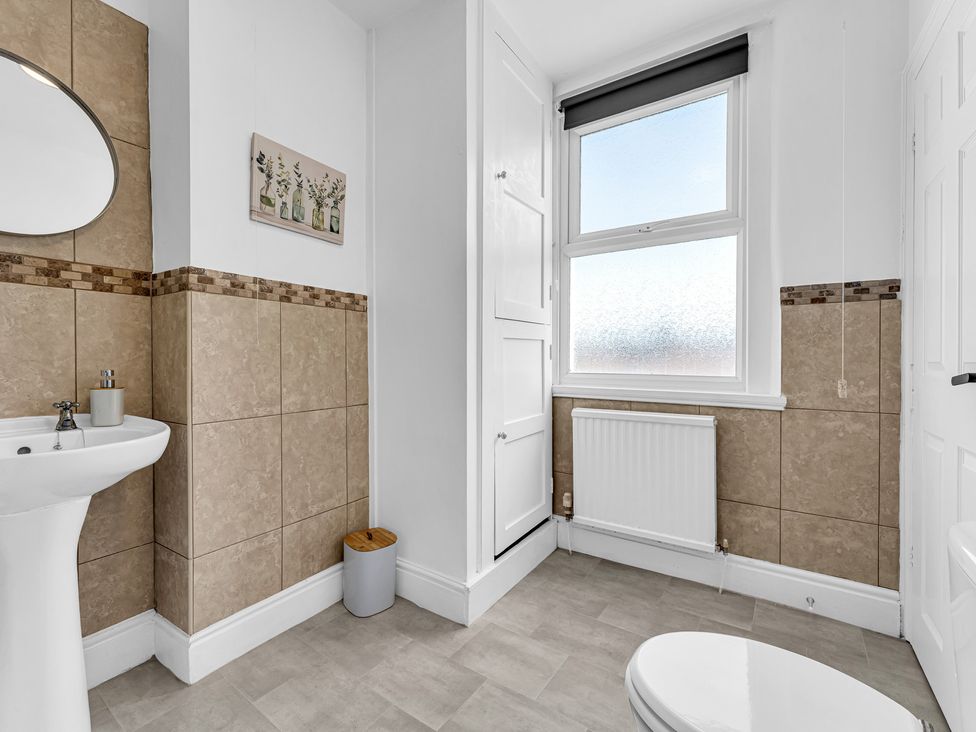 A bathroom with a sink, mirror, and toilet at Peak Side Terrace in Buxton