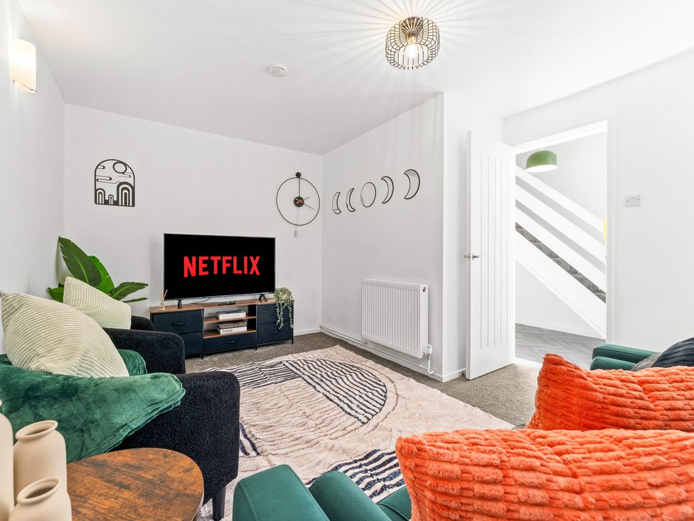 A living room with a television and sofa at Edison House in Stafford