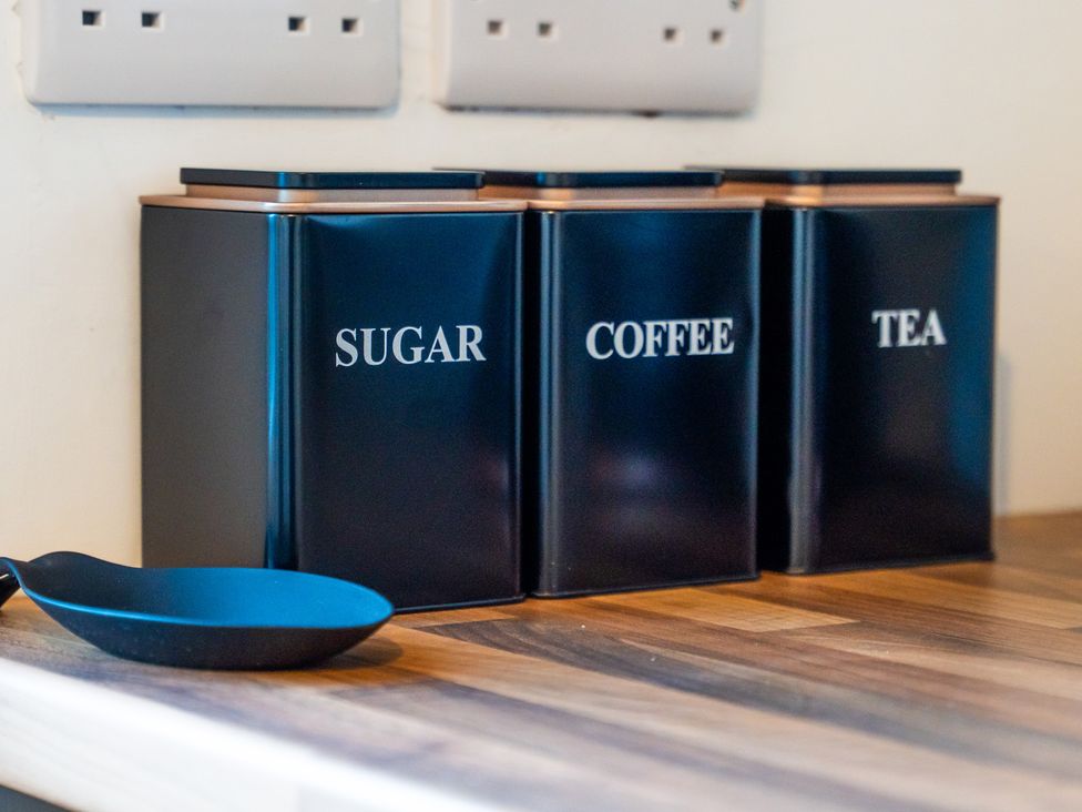 A kitchen with sugar, coffee, and tea containers on the worktop at Edison House Stafford