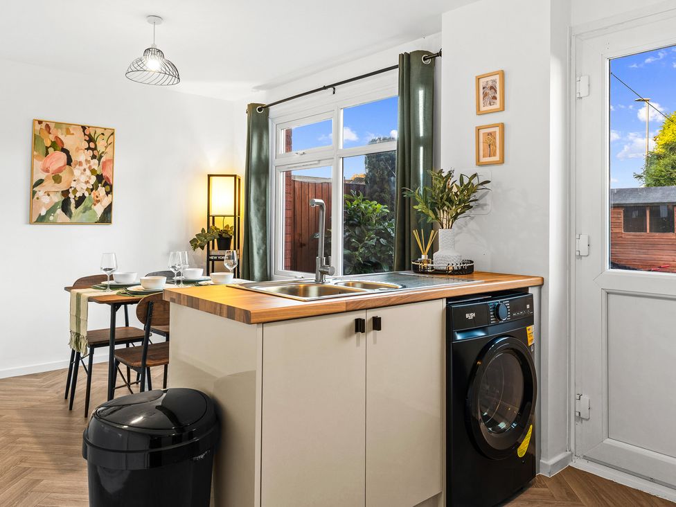 A kitchen with a sink and washing machine at Edison House Stafford