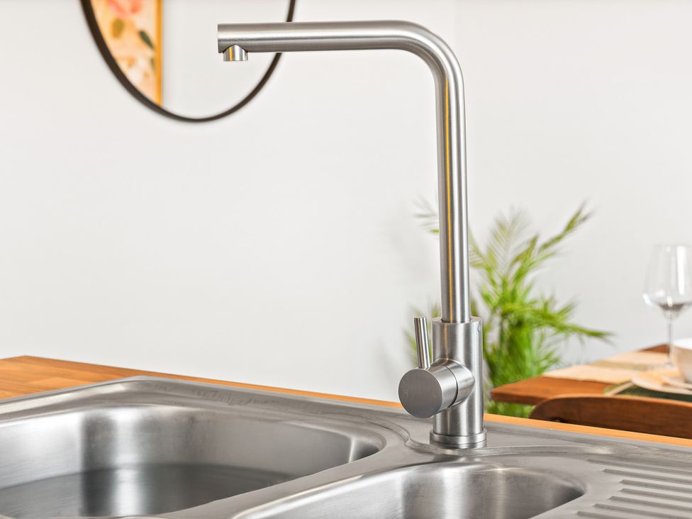 A kitchen with a stainless steel faucet over a sink at Edison House Stafford