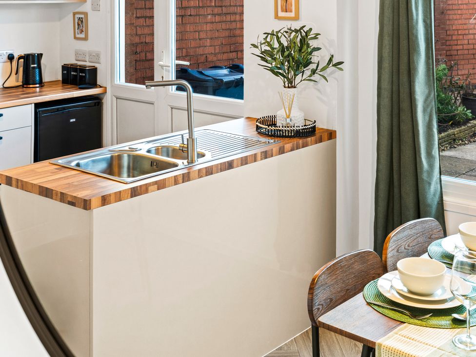 A kitchen with a sink and dining area at Edison House Stafford