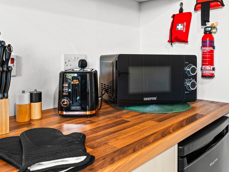A kitchen with a toaster and microwave on a countertop at Edison House in Stafford