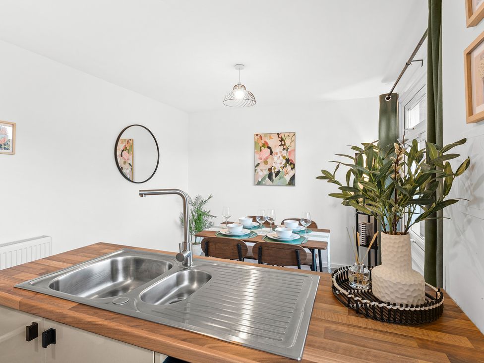 A kitchen with a sink and dining table setup at Edison House Stafford