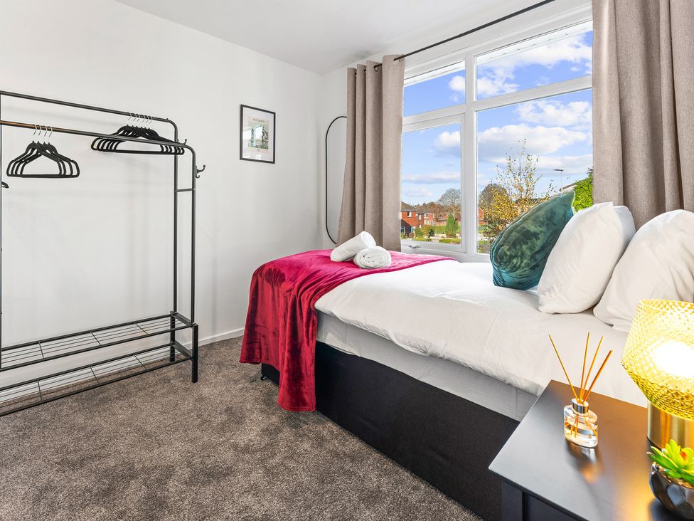 A bedroom with a bed and clothes rack at Edison House Stafford